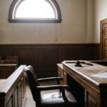 Empty courtroom with a jury summons letter and gavel on the judge's bench, illustrating missing jury duty and possible legal consequences.